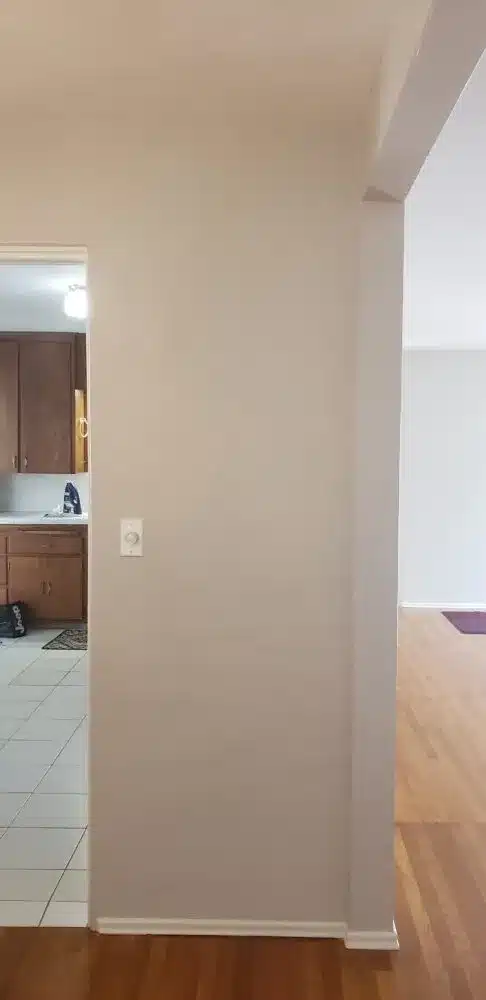 Interior view of a dividing wall between kitchen and living space before renovation.