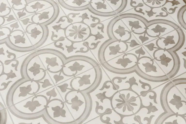 Close-up of decorative gray and white patterned kitchen floor tile in a floral and geometric design.