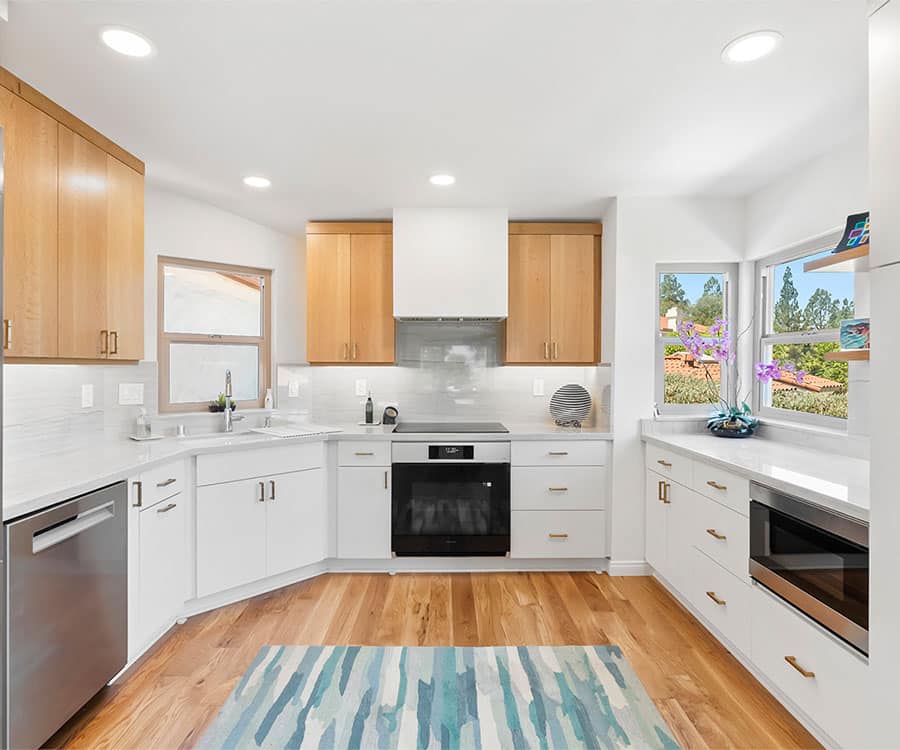 Modern kitchen remodel with white cabinetry, wood upper cabinets, and stainless steel appliances